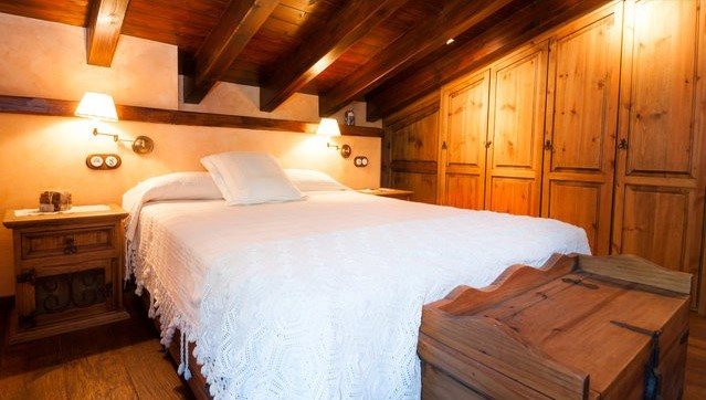 Habitación doble con armario de madera y ropa de cama blanca